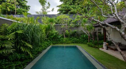 Luxurious villa pool surrounded by lush tropical greenery in Bali, Indonesia.