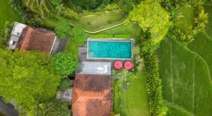 Aerial shot of a beautiful villa with a pool surrounded by lush greenery in Bali, Indonesia.