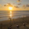 Beautiful sunset on Seminyak Beach, Bali with people enjoying the view and golden sands.